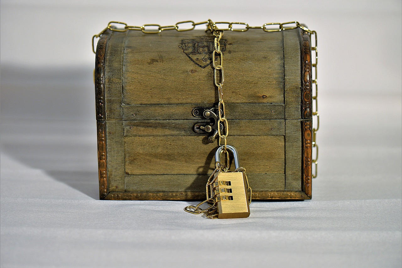 Coffre au trésor fermé par un cadenas à combinaison et une chaîne, symbole d'un escape game en famille