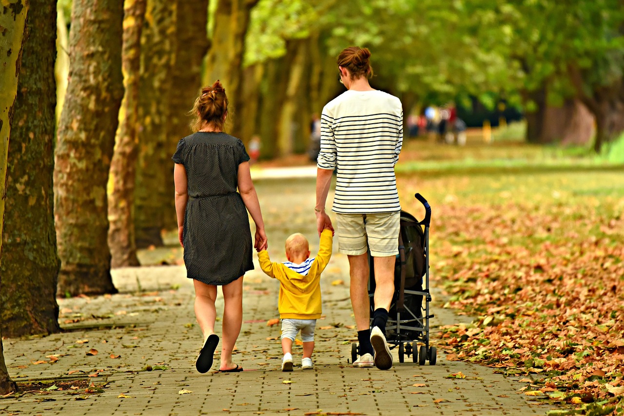 Famille avec un jeune enfant en poussette lors d'une sortie dans un parc